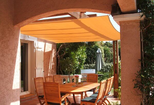 Breathable shade sail above a pergola patio